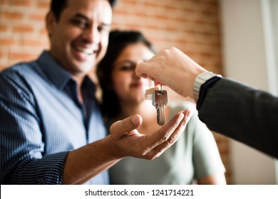 Cheerful couple with keys to their new home