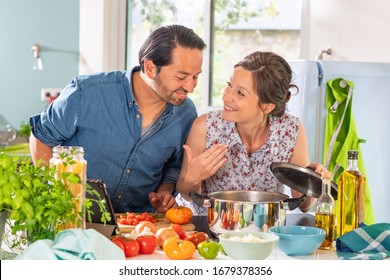 Cheerful Couple in the kitchen preparing an Italian sauce - Powered by Shutterstock