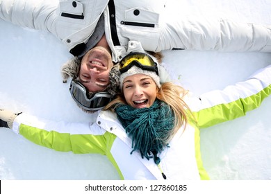 Cheerful Couple Laying Down In Snow