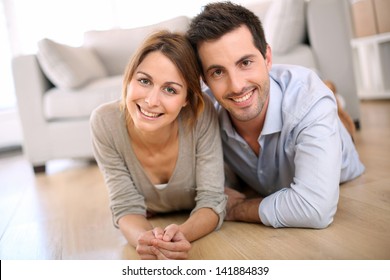 Cheerful Couple Laying On The Floor At Home