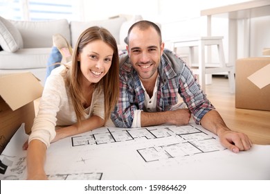 Cheerful Couple Looking At Construction House Plan 
