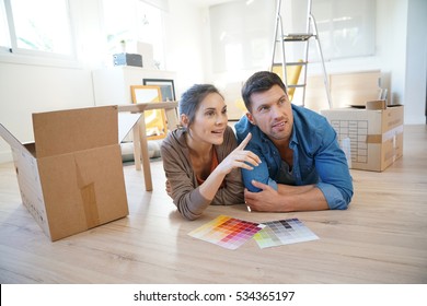 Cheerful Couple Moving In New Home, Choosing Wall Paint Colours