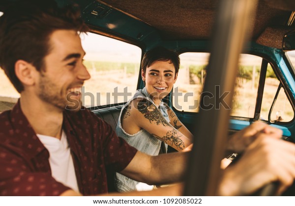 Cheerful couple on a road trip. Smiling man and\
woman talking while driving in\
car.
