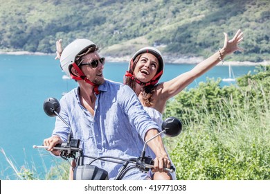 Cheerful couple riding scooter at seaside, vacation concept - Powered by Shutterstock