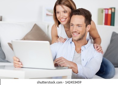 Cheerful Couple Searching Something On Laptop At Home