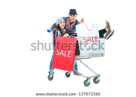 Cheerful couple with a shopping trolley. Isolated over white background.