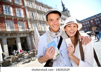 Cheerful Couple Showing Visitor Pass Of Madrid