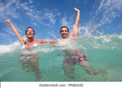 Cheerful Couple Swimming In The Ocean