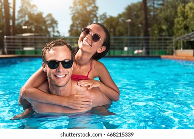 Cheerful couple swimming in a pool - Powered by Shutterstock