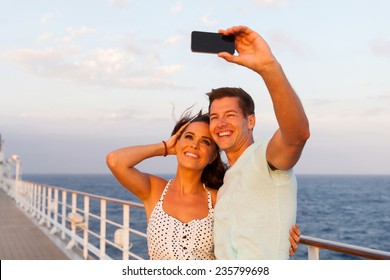 cheerful couple taking photo of themselves on cruise ship - Powered by Shutterstock