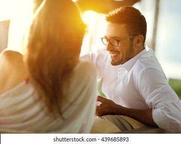 Cheerful couple talking, man smiling and looking at girl 