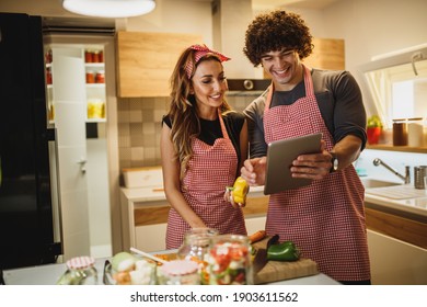 A Cheerful Couple Trying Out A New Recipe In The Kitchen Together.