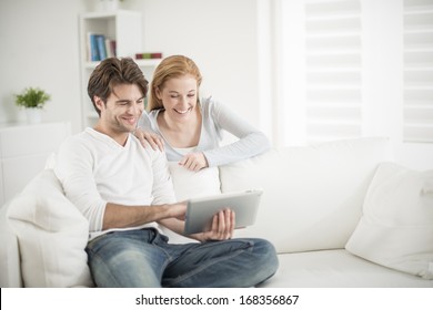 Cheerful Couple Watching A Digital Tablet