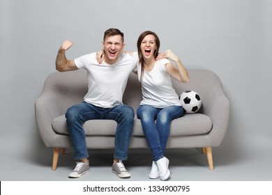 Cheerful Couple Woman Man Football Fans Cheer Up Support Favorite Team With Soccer Ball, Hugging, Clenching Fists Isolated On Grey Background. People Emotions, Sport Family Leisure Lifestyle Concept