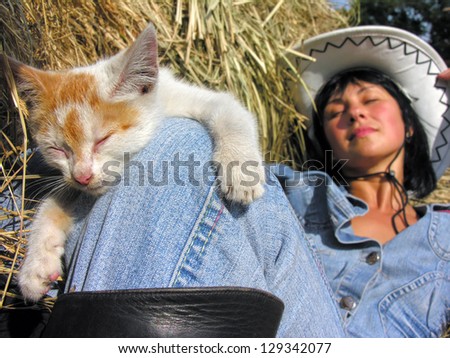 cheerful cowgirl playing with funny kitten in the ranch (in series) - relaxing time