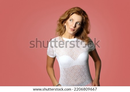 cheerful and coy russian woman look flirty in pink background with eyes to side