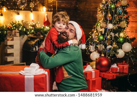 Cheerful cute child opening a Christmas present. Gift emotions. Happy son and father with Christmas gift box. New year concept The morning before Christmas