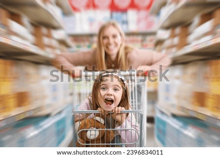 Similar – Image, Stock Photo Mother pushing shopping cart with her infant baby boy child down department aisle in supermarket grocery store. Shopping with kids concept.