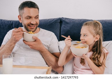 Cheerful Dad With Adorable Daughter Having Breakfast In Bed On Fathers Day Together