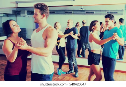 Cheerful Dancing Couples Learning Salsa At Dance Class