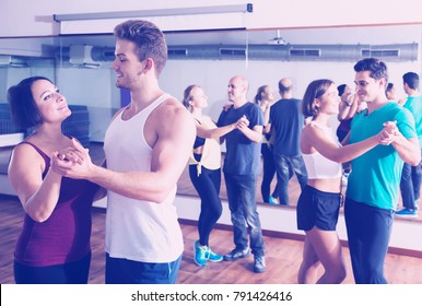 Cheerful Dancing Couples Learning Salsa At Dance Class