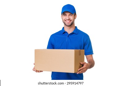 Cheerful delivery man. Happy young courier holding a cardboard box and smiling while standing against white background