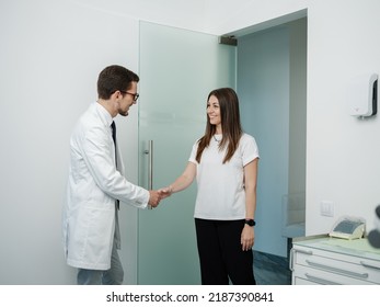 Cheerful Dentist Welcomes His Patient And Shaking Hands In Dental Office