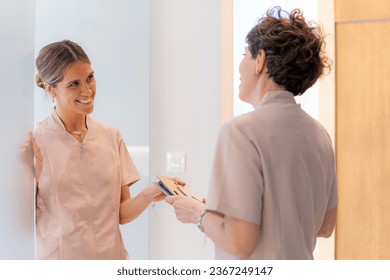 Cheerful dentists talking relaxed in the clinic during a shift - Shutterstock ID 2367249147