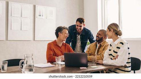 Cheerful designers smiling happily while having a meeting in an office. Group of successful businesspeople working on a new interior design project in a creative workplace. - Powered by Shutterstock