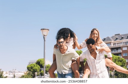 Cheerful diverse friends enjoying piggyback ride in park - Powered by Shutterstock