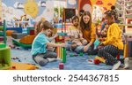 Cheerful Diverse Kids Playing with Colorful Building Block Toys in Kindergarten. Group of Multiethnic Boys and Girls Playing Together with a Female Teacher in a Modern Daycare Center