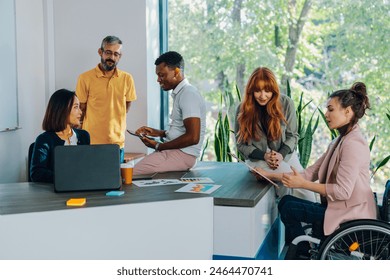 Cheerful diverse office people group talking and enjoying teamwork during staff meeting. Happy multiracial coworkers have fun working together at office brainstorming. Teamwork concept. - Powered by Shutterstock