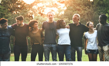 Cheerful diverse people huddling in the park - Shutterstock ID 1355507276
