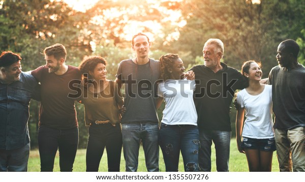 Cheerful diverse\
people huddling in the\
park