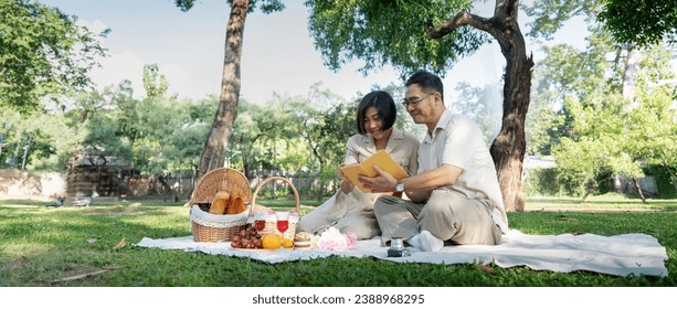 Cheerful elderly couple asian wear casual clothes sitting in the park having a party together - Powered by Shutterstock