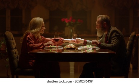 Cheerful elderly couple spending time together romantic restaurant. Happy old aged family marriage anniversary celebration home evening supper. Smiling mature senior people clinking wine glasses - Powered by Shutterstock