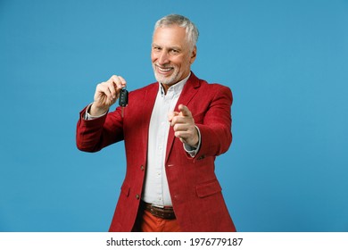 Cheerful Elderly Gray-haired Mustache Bearded Business Man Wearing Red Jacket Suit Standing Hold In Hand Car Keys Pointing Index Finger On Camera Isolated On Blue Color Background Studio Portrait