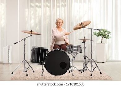 Cheerful Elderly Woman Playing Drums At Home