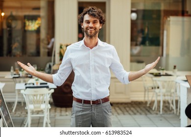 Cheerful Elegant Man, Standing Outside In The Street In Front Of His Restaurant