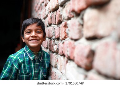 Cheerful elementary age child portrait near brick wall.