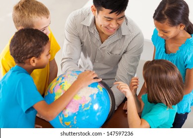 cheerful elementary school teacher with a globe teaching geography