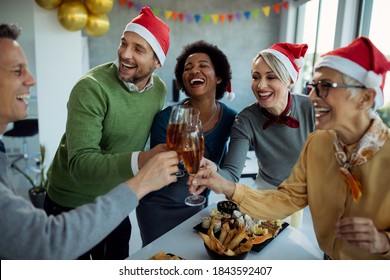 Cheerful entrepreneurs having fun while toasting with Champagne on New year's party in the office.  - Powered by Shutterstock