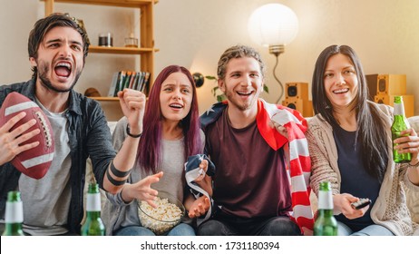 Cheerful Excited Four Friends Are Watching American Football On Tv At Home While Drinking Alcohol Beverages And Eating Popcorn