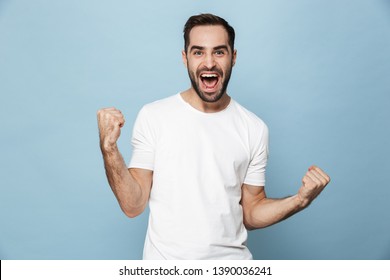 Cheerful Excited Man Wearing Blank T-shirt Standing Isolated Over Blue Background, Celebrating Success