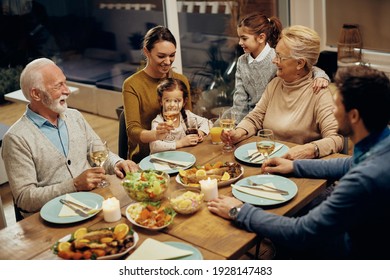 Cheerful Extended Family Communicating While Gathering Around Dining Table At Home. 