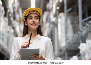 Cheerful Factory Woman Thinking And Checking Retail Stock In Warehouse Storage. Female Worker Working For  Logistic Business Shipping And Delivery Service. Copy Space