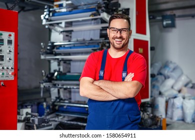 Cheerful factory worker with arms crossed.