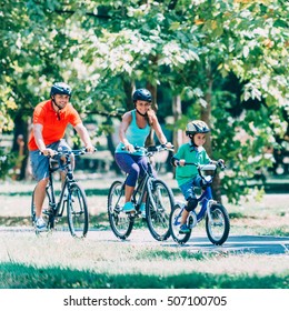 Cheerful Family Biking In Park