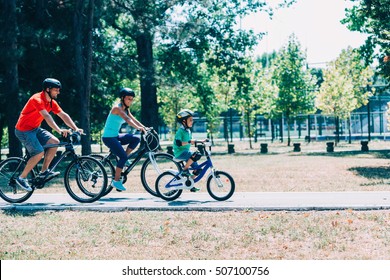 Cheerful Family Biking In Park