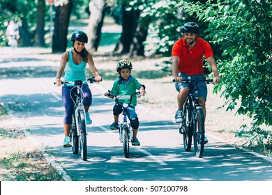 Cheerful Family Biking In Park